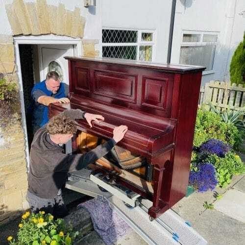 Piano being lifted over a wall where access is difficult